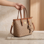 premium embossed leather handbag with a luxury golden chain braided handle and iconic lion emblem hardware.
